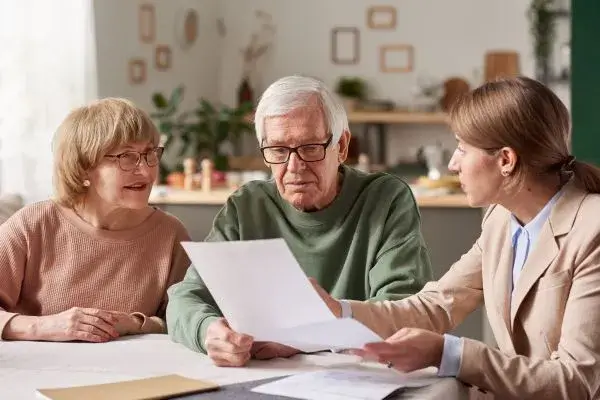 A family comfortably discussing Will At Home services with a professional advisor in a relaxed home setting